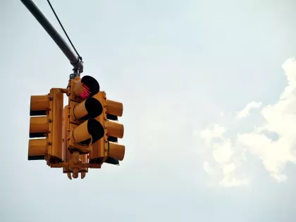 a cropped image of a stop light against a clear blue sky